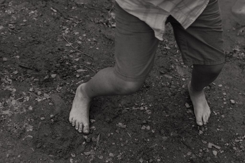 little boy's feet playing near water 
