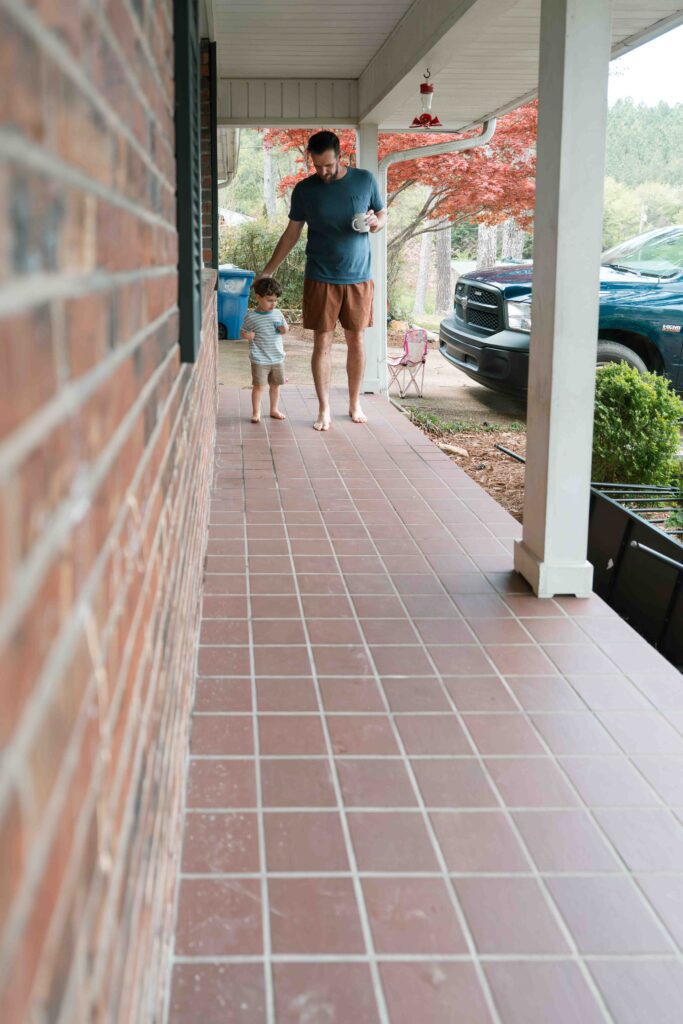 little boy and dad on front porch of home