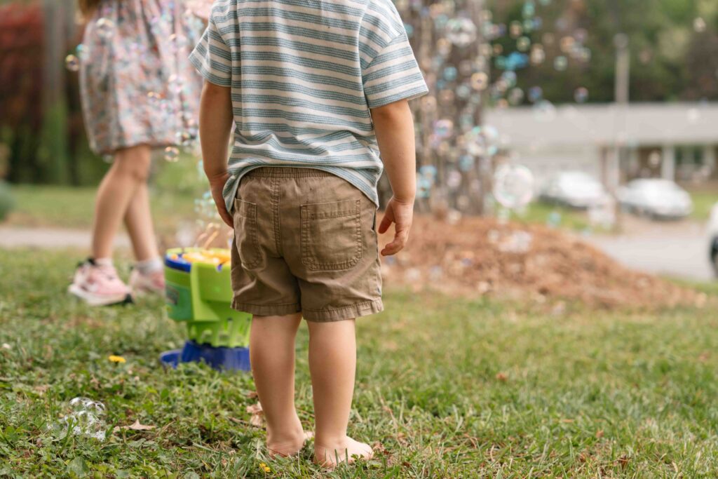 little boy and sister playing in bubbles