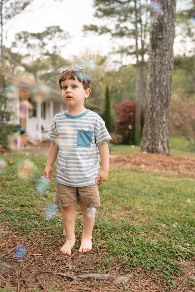 little boys playing in bubbles outside