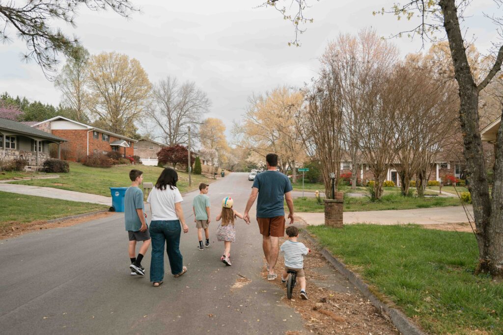 family taking a walk down the street from their home
