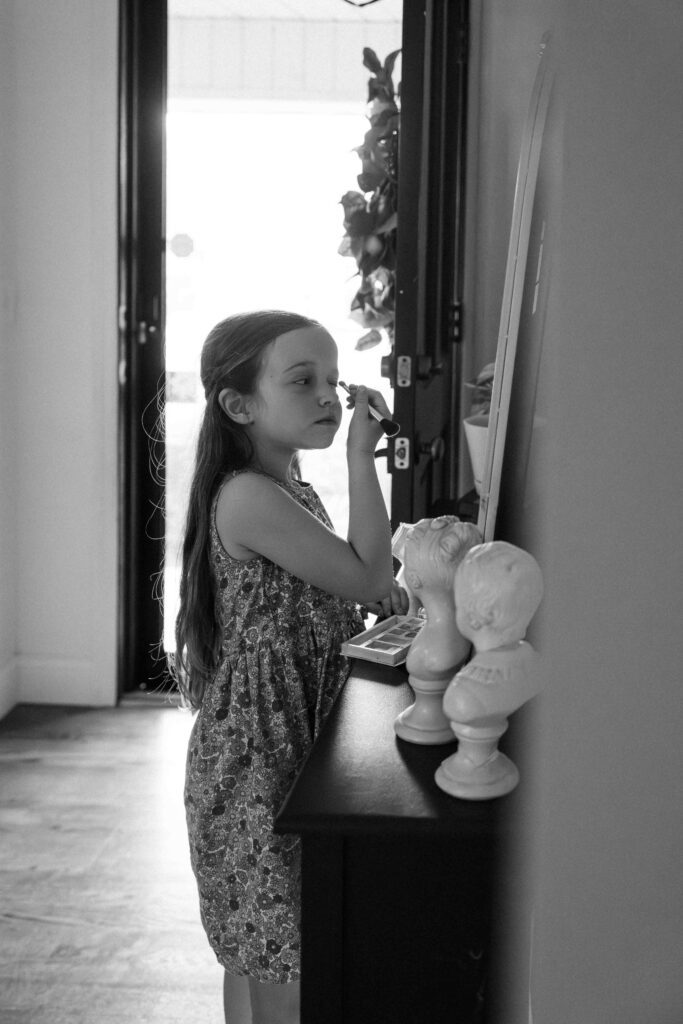 little girl putting on makeup inside of home