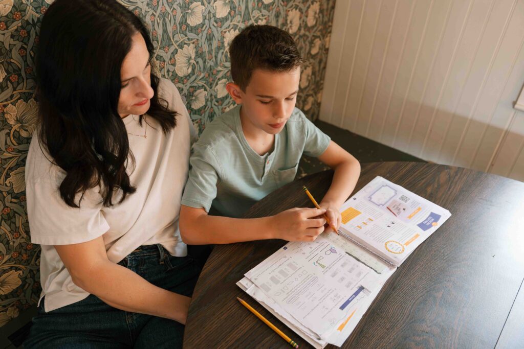 mom homeschooling her little boy at kitchen table