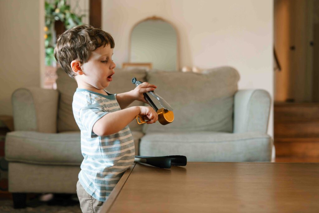 little boy playing with kitchen utensils at home