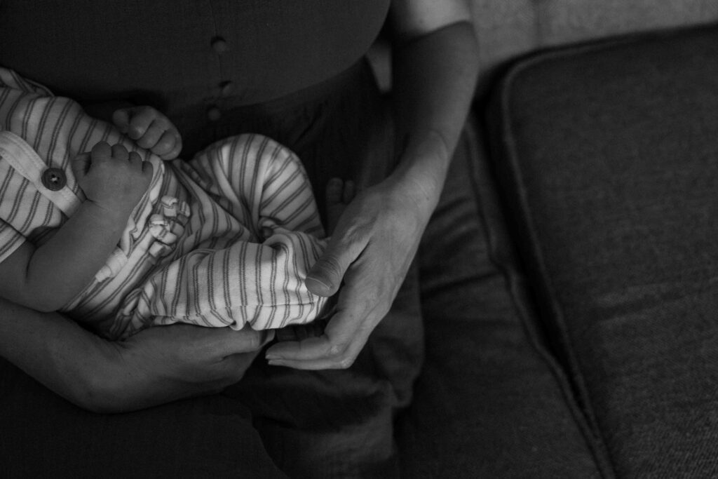mom holding baby's feet on couch