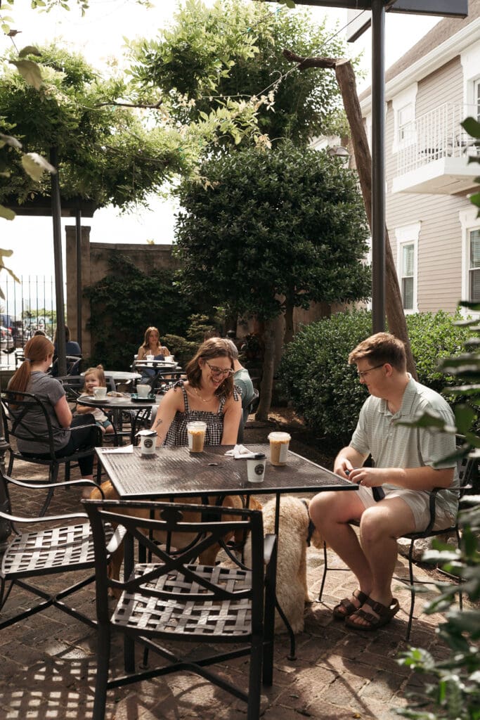 A couple enjoys coffee together with their dog on the patio at Rembrandt’s Coffee House in Chattanooga on a sunny afternoon.