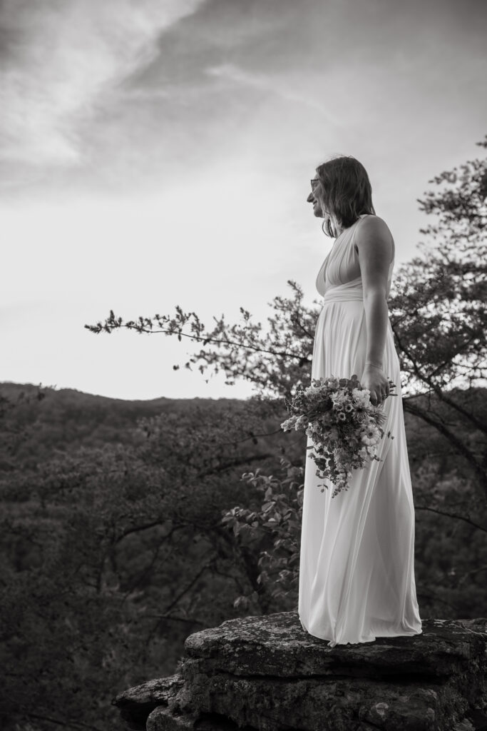 Bride standing on a mountain overlook holding her bouquet during her Tennessee elopement